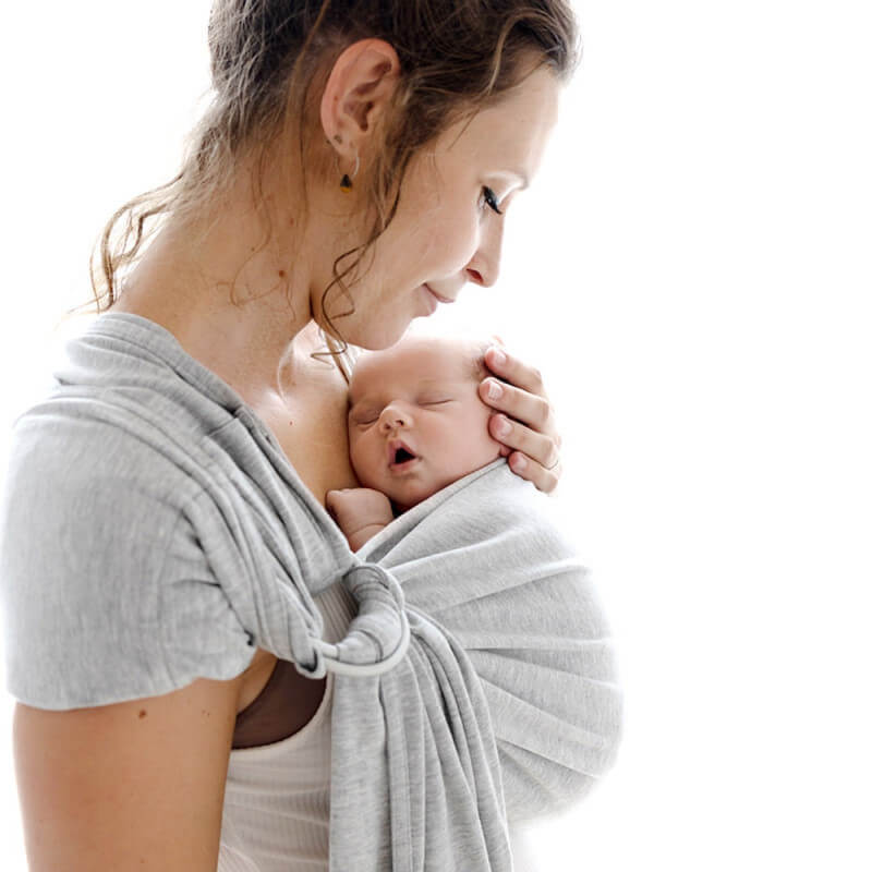 Mother carrying her newborn in the Love Radius baby wrap, side view