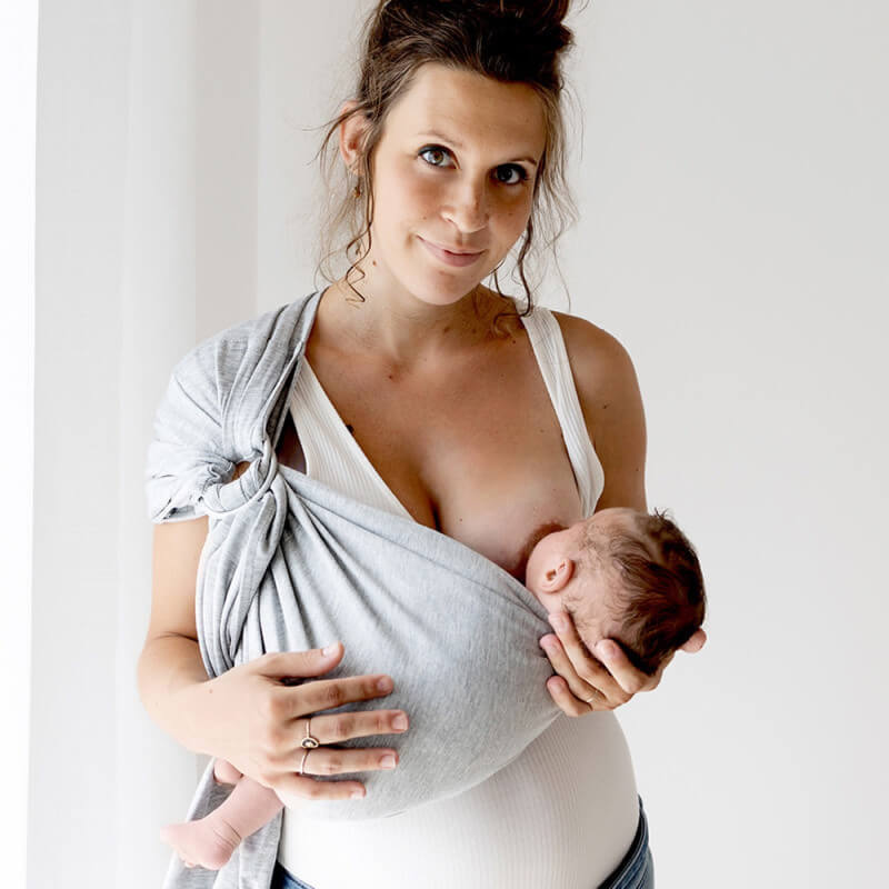 Frau stillt ihr Baby mit dem Love Radius Tragetuch Petite Chiné
