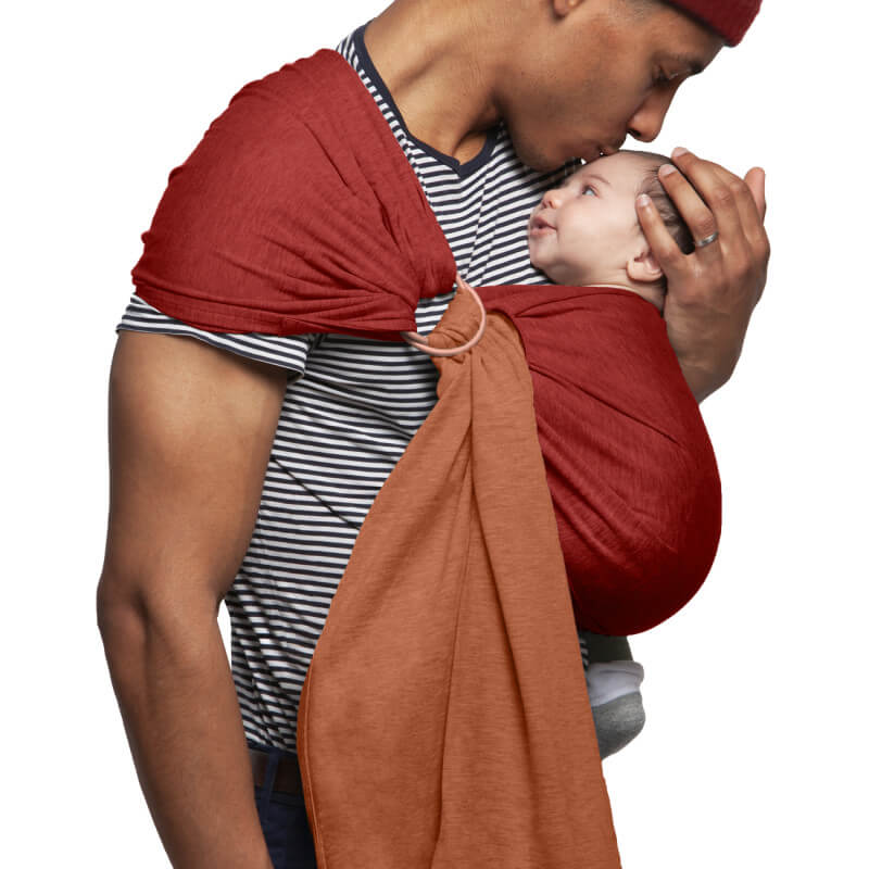 Father carrying baby in Love Radius reversible tawny and burgundy Sling