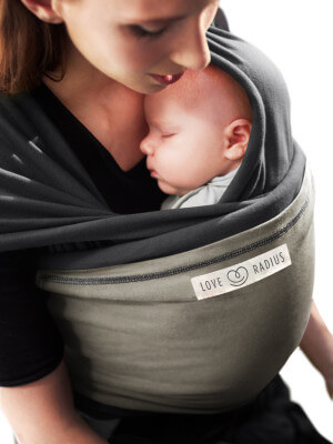 The Imperfects - Wrap JPMBB Original - ANTHRACITE, Olive Mother wrapping her baby in the Love Radius JPMBB anthracite baby wrap