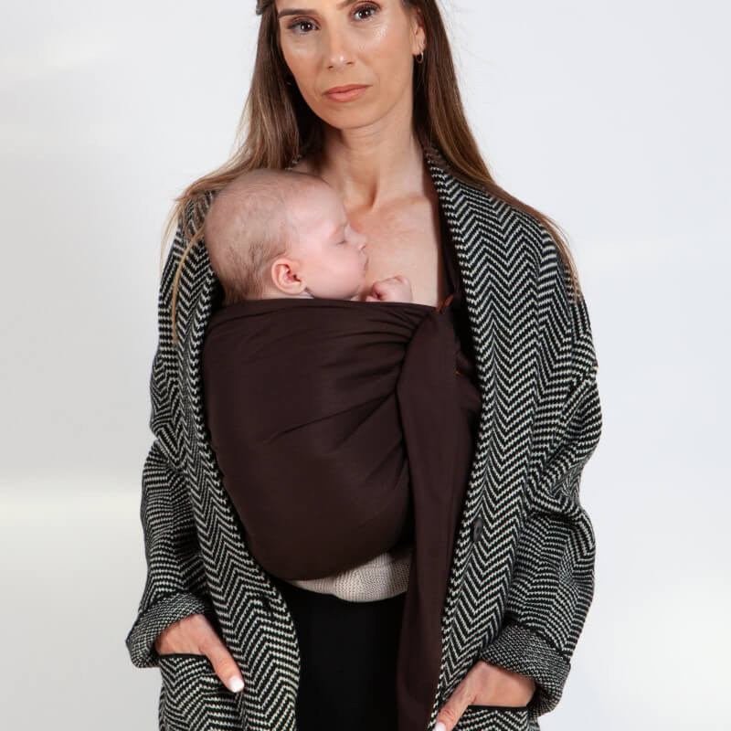 Mutter trägt Love Radius Sling Tragetuch Espresso zum diskreten Stillen