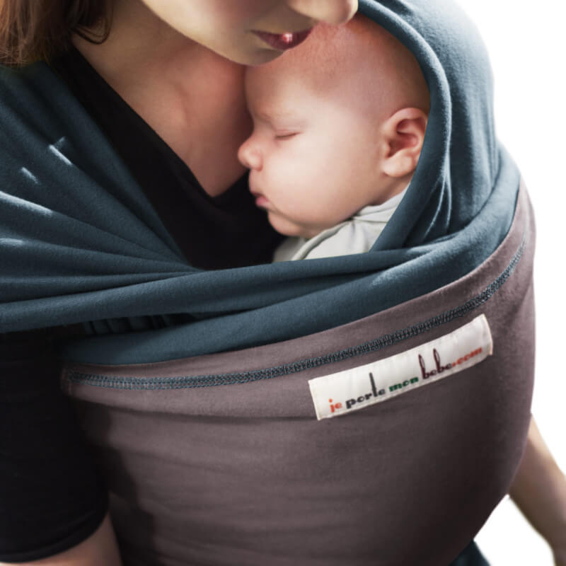 Moeder draagt slapende baby in Love Radius L'Originale draagdoek blauw en bruin