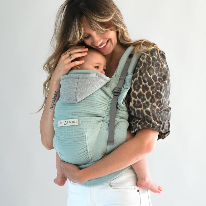 Mamma che indossa il marsupio Love Radius HoodieCarrier 2 colore salvia
