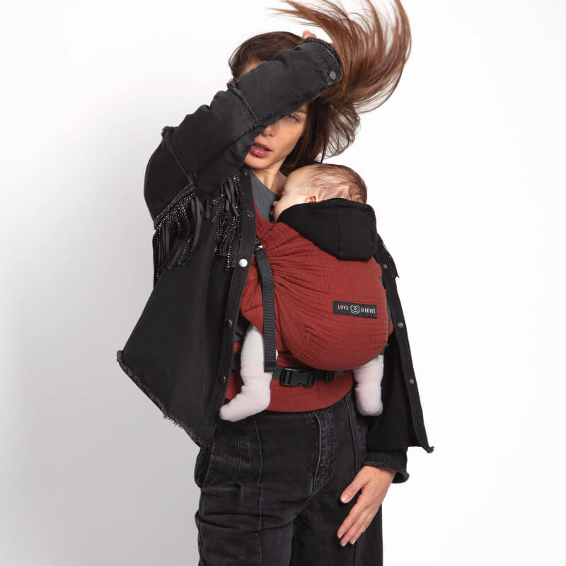 Love Radius HoodieCarrier 2 Babytrage in Rot, getragen von einer Mutter mit ihrem Baby