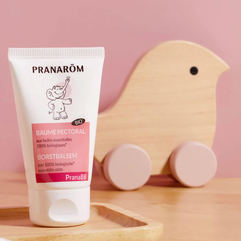 Pranarôm PranaBB Baume pettorale bio presentato con giocattolo in legno per bebè