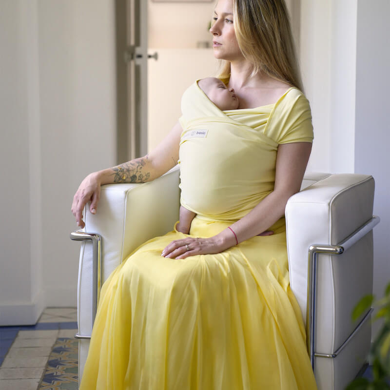 Terhes nő Love Radius Mimosa sállal, kényelmesen ülve, praktikus szoptatási bemutatóval