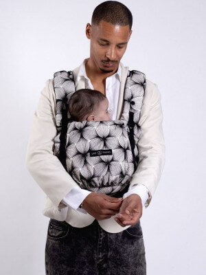 Vader draagt Love Radius PhysioCarrier 2 met baby in ventrale positie, zwart patroon