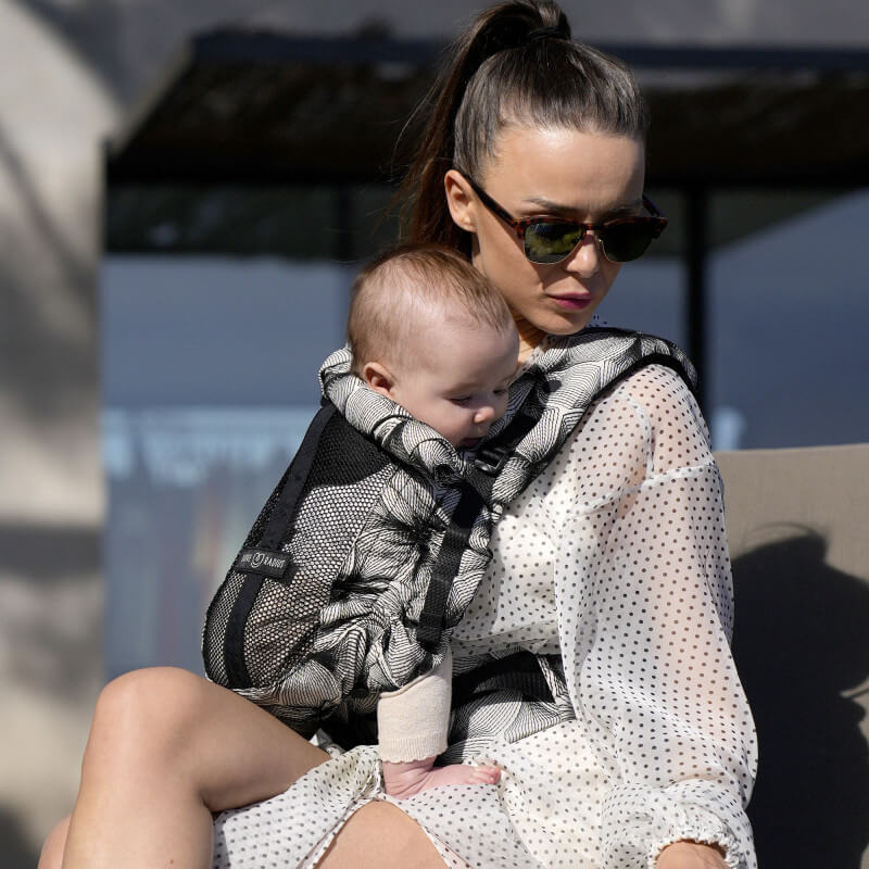 Donna che porta bambino con Love Radius PhysioCarrier 2 Black Orchid all'aperto