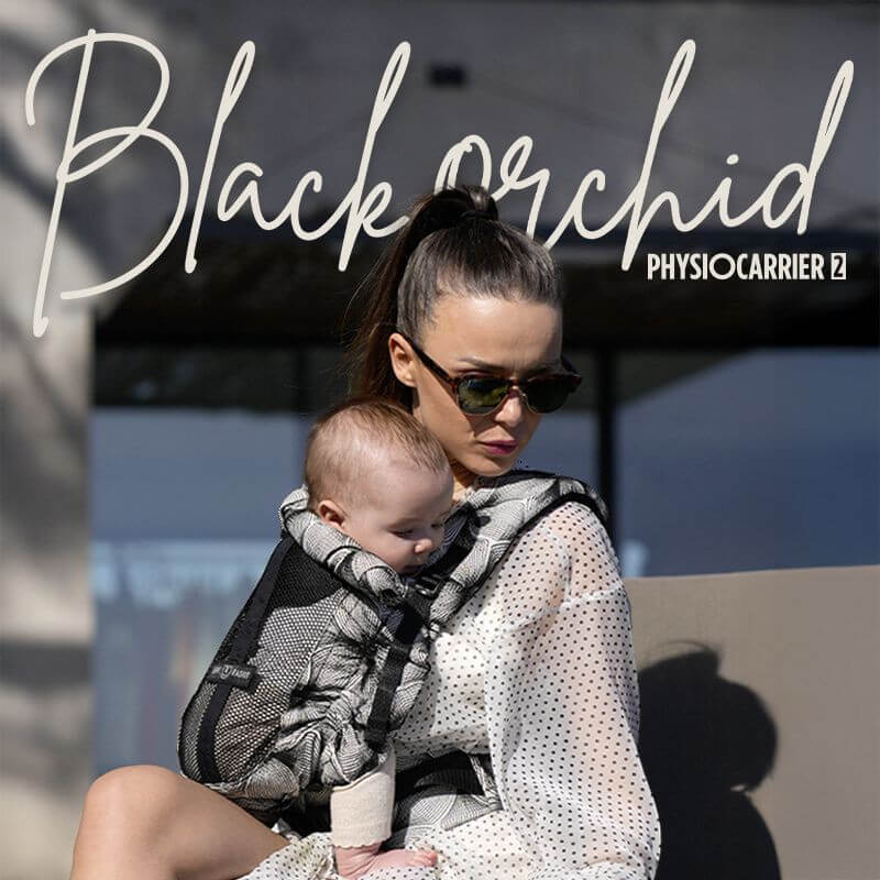 Madre llevando el portabebés Love Radius PhysioCarrier 2 Black Orchid en el exterior, vista de perfil