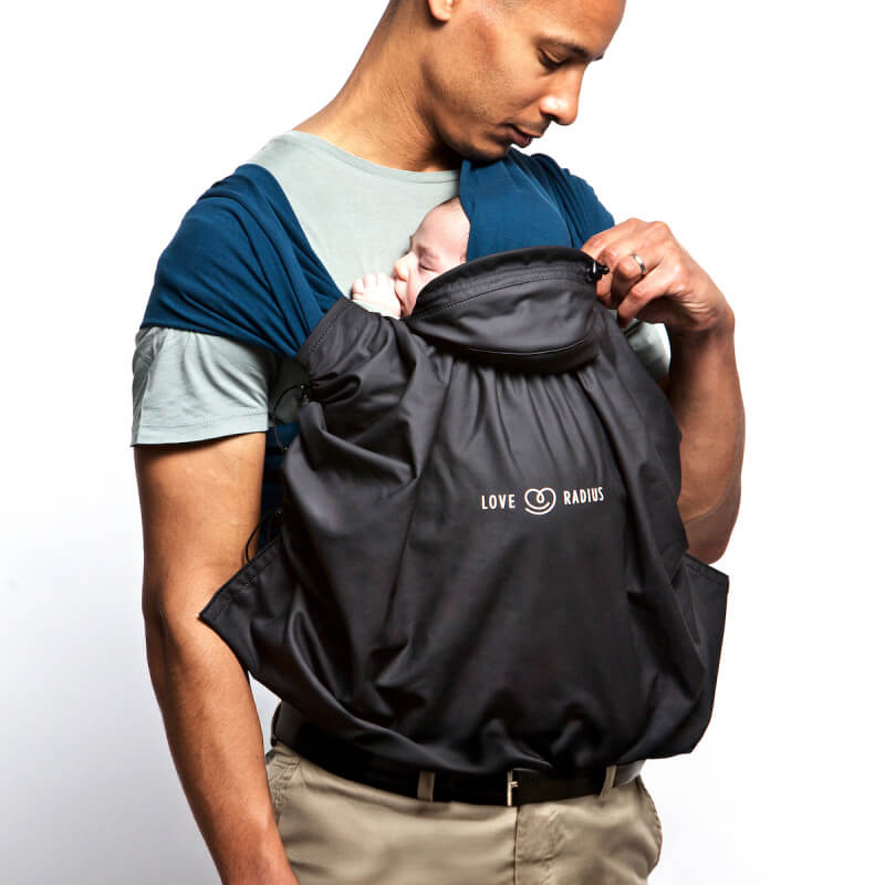 Love Radius funda de porteo impermeable negra, utilizada en situación de porteo padres-hijo