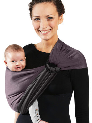 A Tökéletlenek - Sling - No Knot Little Wrap - Antracit, Marron Glacé Anya babáját Love Radius antracit csatos kendőben hordja, mosolyogva a kamera felé