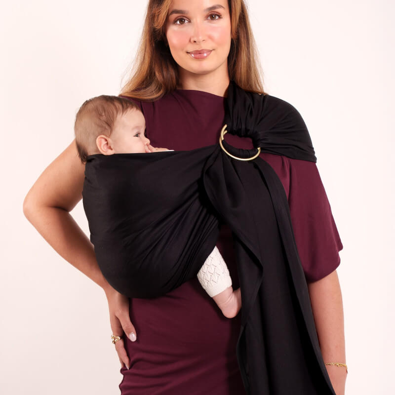 Madre che porta il suo bambino nella fascia nera Love Radius senza nodo