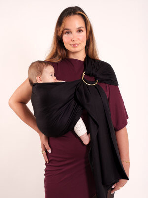Die Unvollkommenen - Sling No Knot Woven Wrap - Black Mutter trägt ihr Baby in der schwarzen knotenlosen Tragetuch-Sling von Love Radius