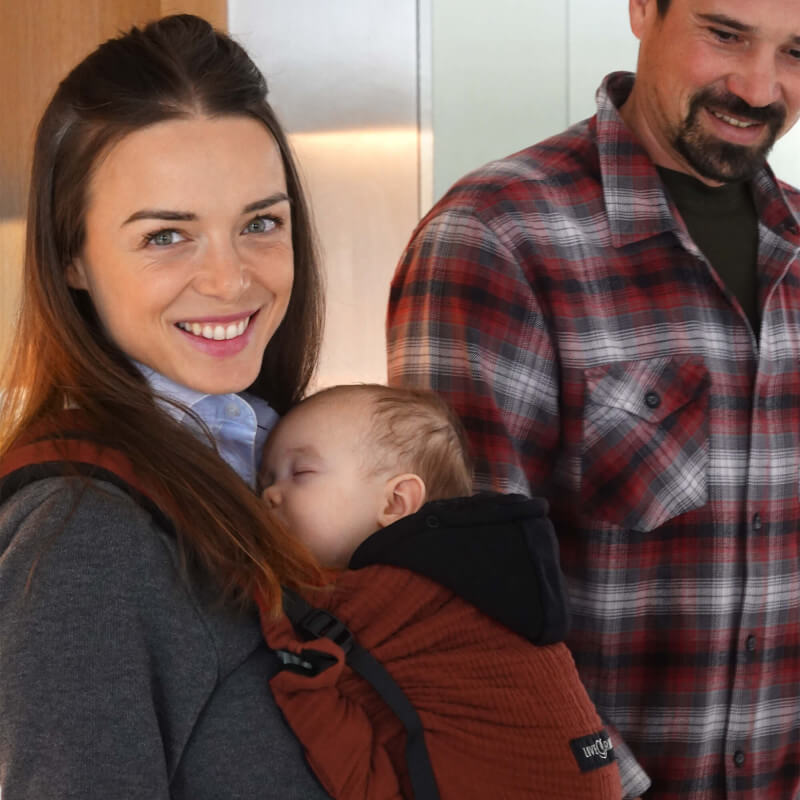 Glimlachend gezin met baby in Love Radius HoodieCarrier 2 Hot Paprika