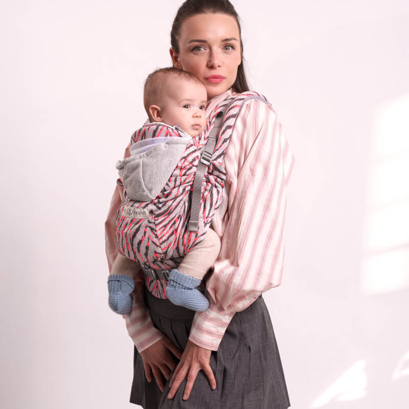 Matka noszaca swoje dziecko w różowym Love Radius HoodieCarrier 2 w paski, widok z przodu