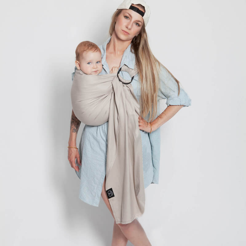 Moeder draagt baby in Love Radius Les Imparfaits sling lichtgrijs, volledig vooraanzicht