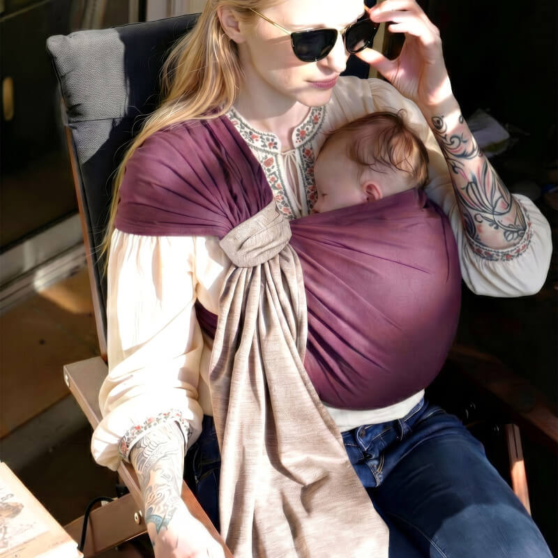 Love Radius Sling reversibel Feige Latte im Gebrauch, stillende Mutter sitzt und hält ihr Baby