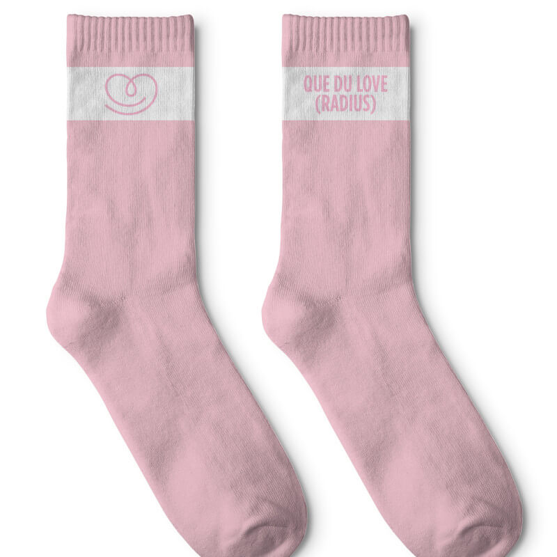 Par Love Radius rosa strumpor med textband QUE DU LOVE, komplett framifrån