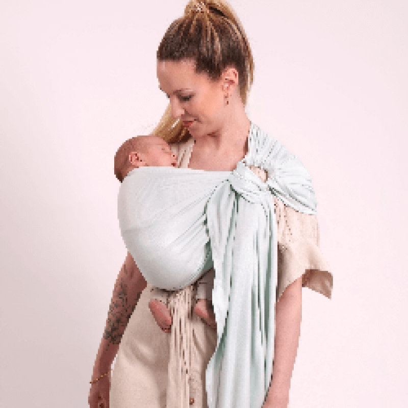 Mère portant son nouveau-né en écharpe tissée Love Radius, vue de profil