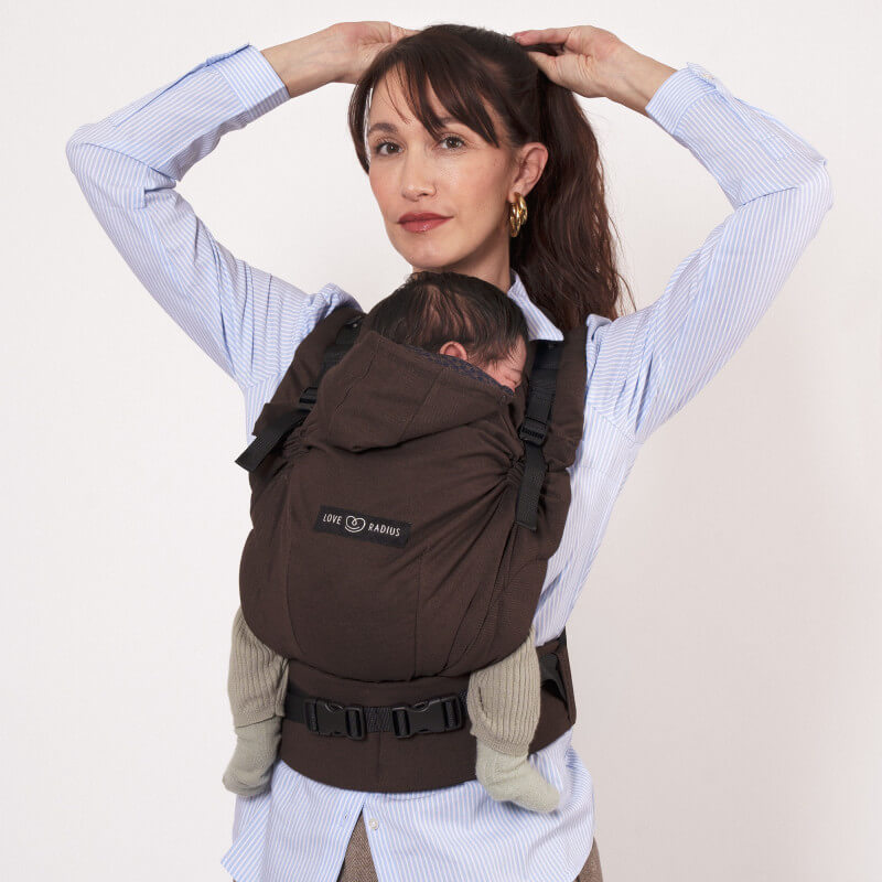 Love Radius HoodieCarrier 2 Wood, mochila porta-bebê marrom vestida por mulher de camisa azul