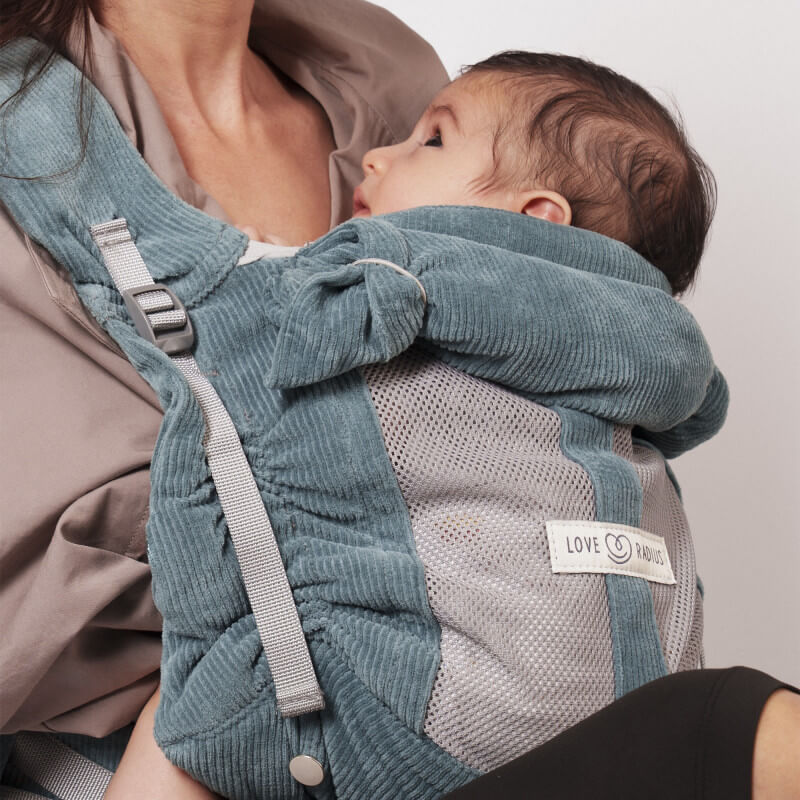Mamma som bär baby i Love Radius PhysioCarrier 2 Velvet Blue blågrå