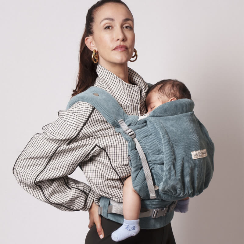 Mamma som bär sitt barn i Love Radius PhysioCarrier 2 Velvet Blue, sedd i profil