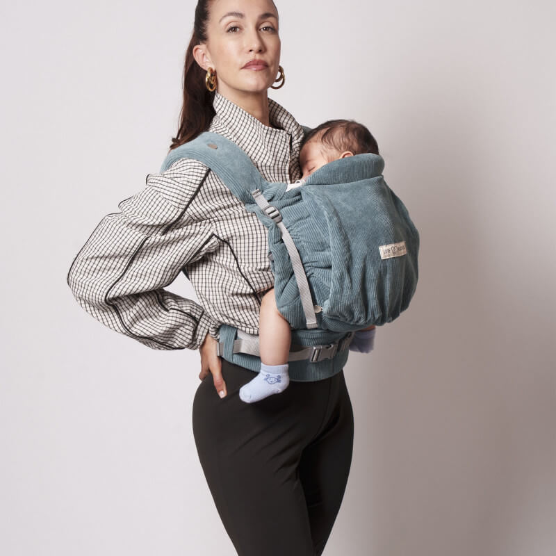 Mamma som bär Love Radius PhysioCarrier 2 Velvet Blue på ryggen med baby inbäddad däri