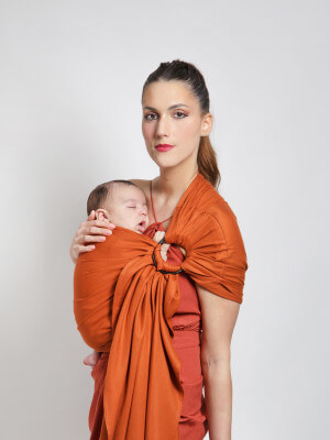 Ring Sling Fascia Tessuta Senza Nodi - Fauve Mamma che porta il neonato addormentato nella fascia tessuta color fulvo Love Radius